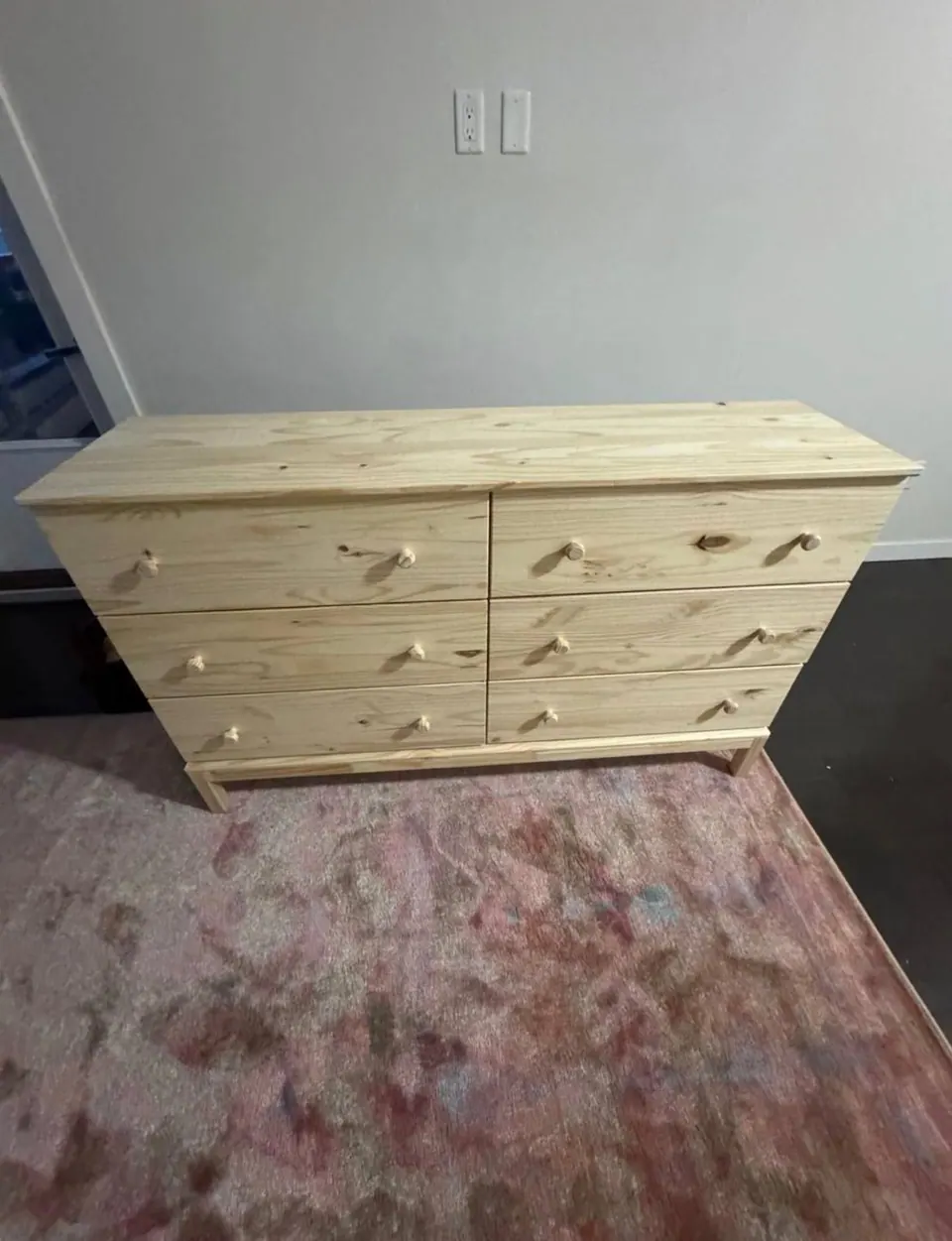 Completed: Assembled six-drawer pine dresser standing against the wall